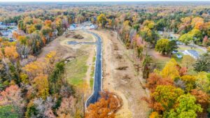 Aerial view of Poplar Village, a residential neighborhood under construction, surrounded by autumn trees.