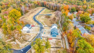 Aerial view of Poplar Villages housing development with fall foliage and newly constructed roads and houses.