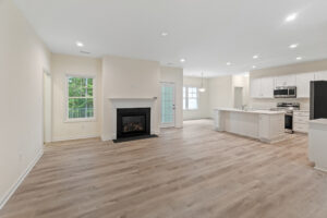 Spacious open-plan living area in Patrick Henry Heights with wooden floors, a fireplace, and a modern kitchen.