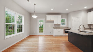 Modern Bethany kitchen with white cabinets, granite countertops, wood floors, and large Somerset Hill windows.