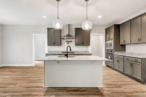 Modern Somerset Hill kitchen with gray cabinets, granite countertops, island, and stainless steel appliances.