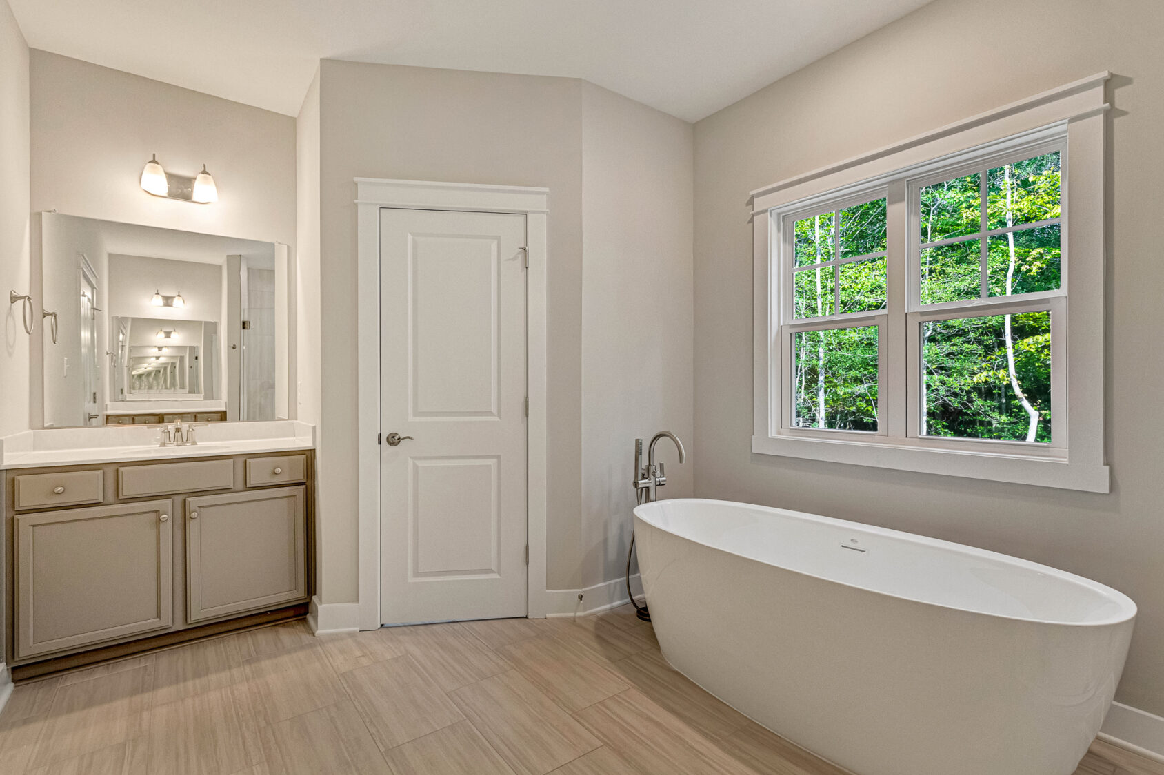 Modern bathroom in Somerset Hill Lot 7 with a freestanding tub, large window, and double sink vanity in neutral tones.
