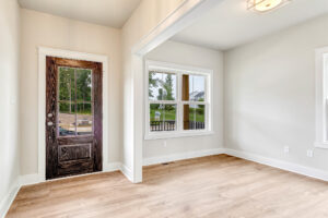 Bright entryway in Lot 20, Somerset Hill with wood door, large windows, light walls, and light wood flooring.