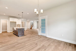 Bright, modern open-concept kitchen on Lot 20, Somerset Hill with wood floors, island, and glass door, unfurnished.